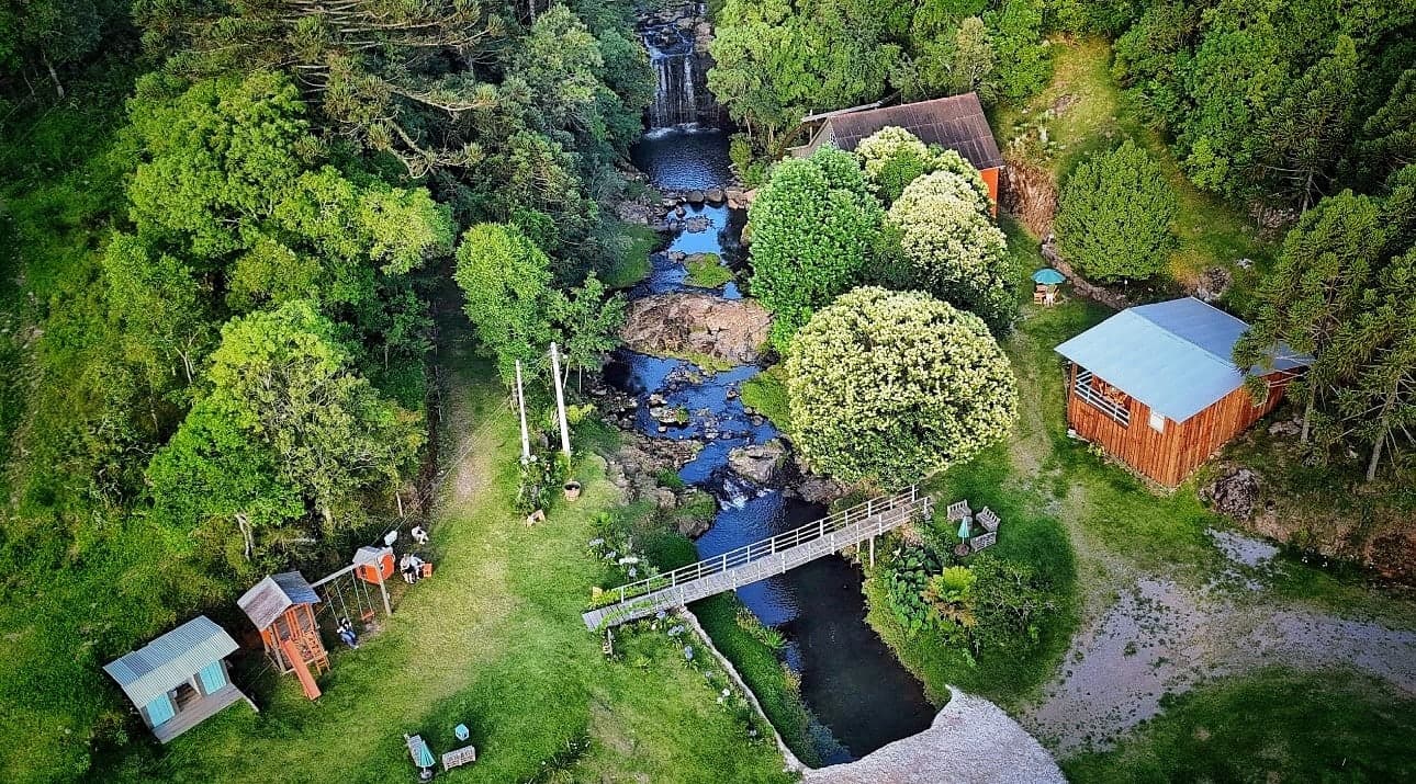 Vista aérea do Moinho Ghinzelli: cascata, riacho, ponte e os espaços da propriedade em meio à natureza